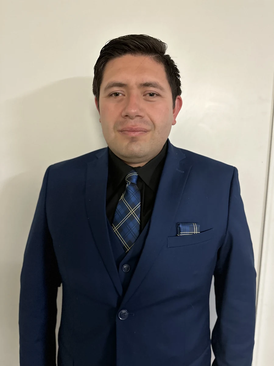 Fernando Macias wearing a navy suit and blue patterned tie.